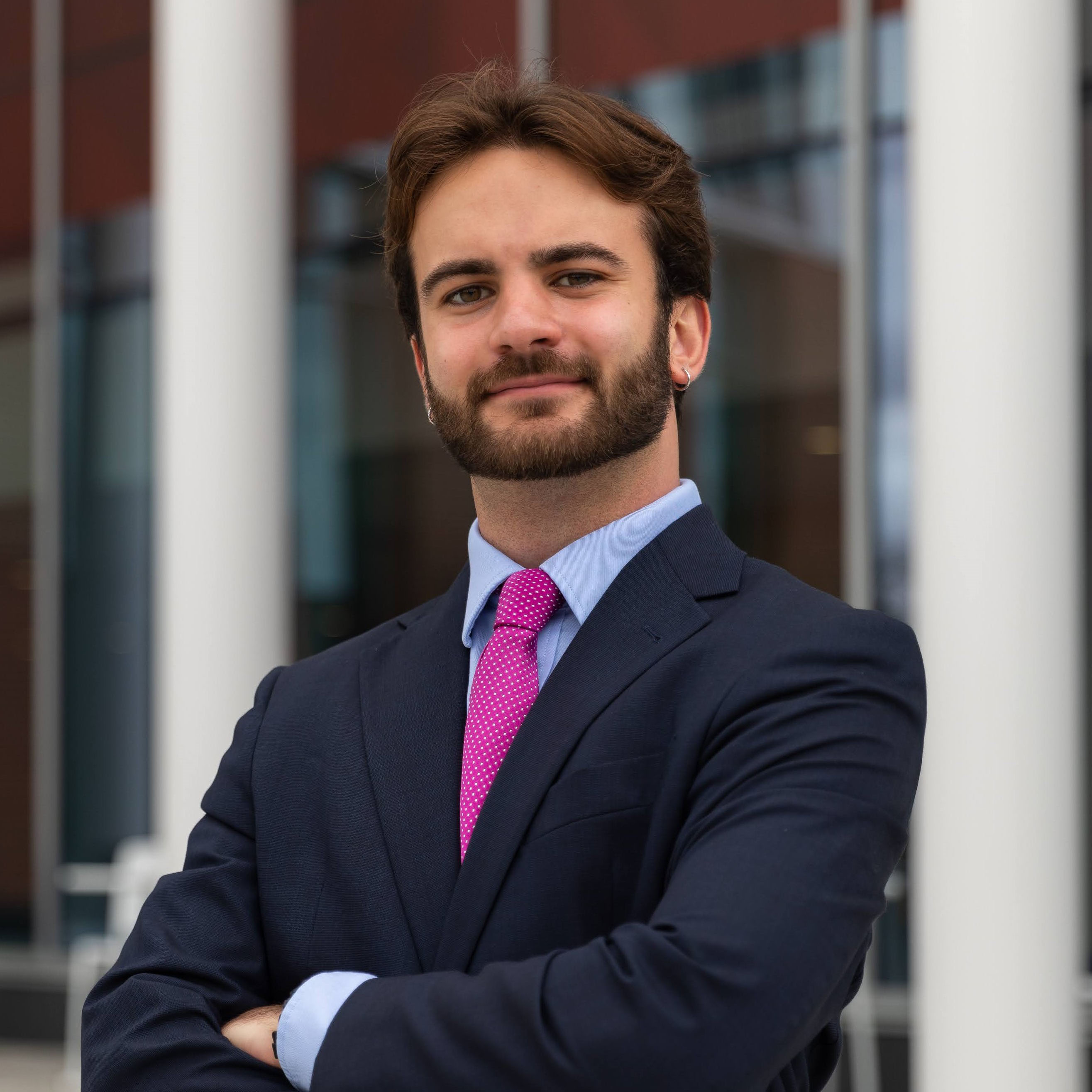 Headshot of Sam Briglia, Operations Manager in a suit standing with confidence